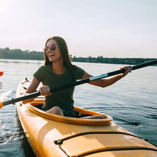 woman kayaking on Vacation paid for with account interest